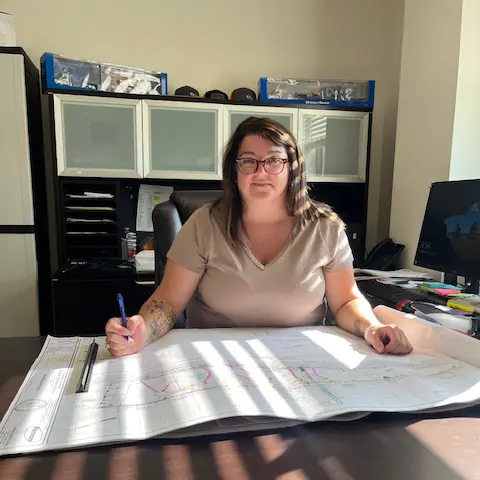 Estimator, Tara Jenkins, sitting at a desk in an office.