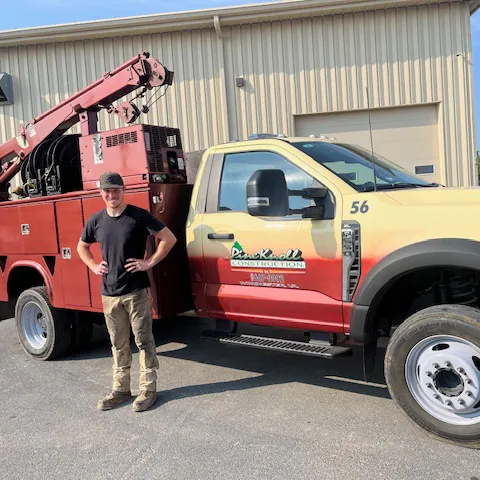 Nick Kilmer standing in front of a Pine Knoll Truck.