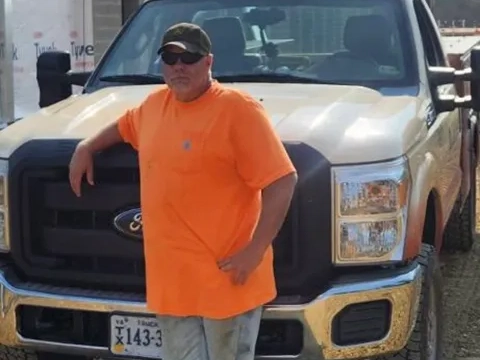 Pete Hahn standing in front of a Pine Knoll Truck.